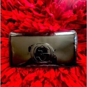 Gucci patent leather bi-fold kiss lock wallet in black.